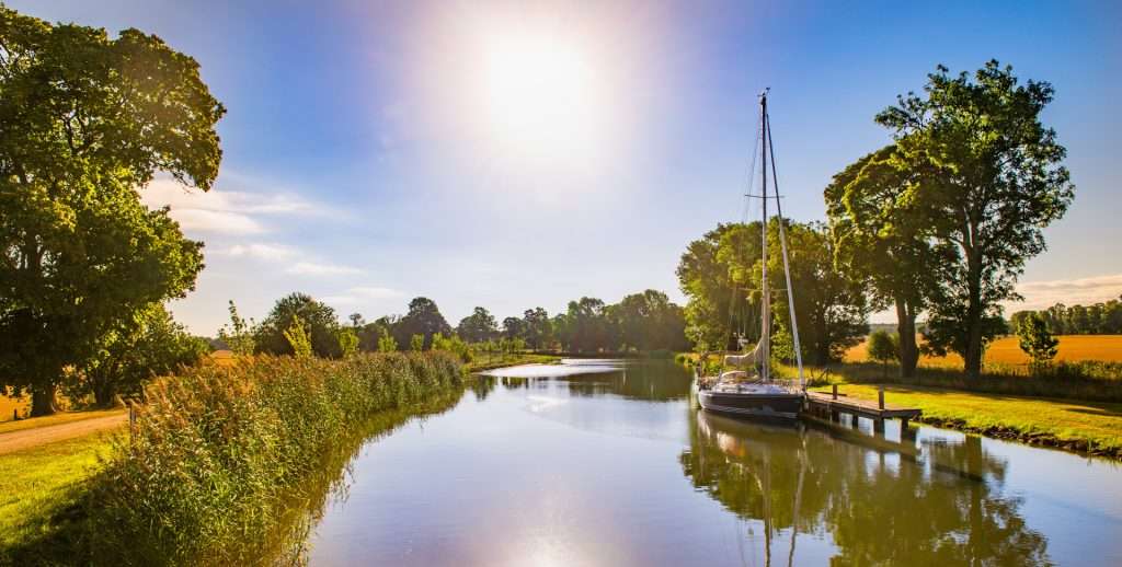Segelbåt vid Göta kanal i kvällsljus Segelbåt vid Göta kanal i kvällsljus
